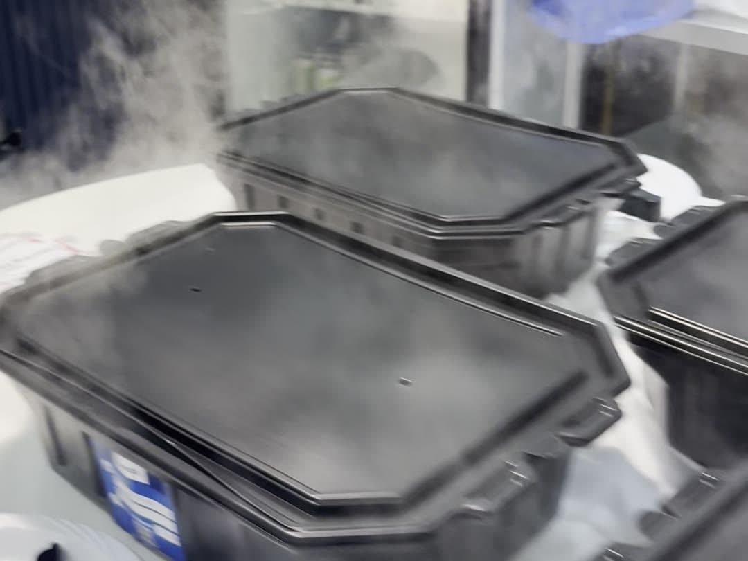 Steam rising from a row of closed self-heating trays on a service table